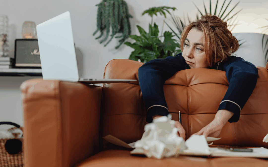 woman looking at laptop stressed over paperwork