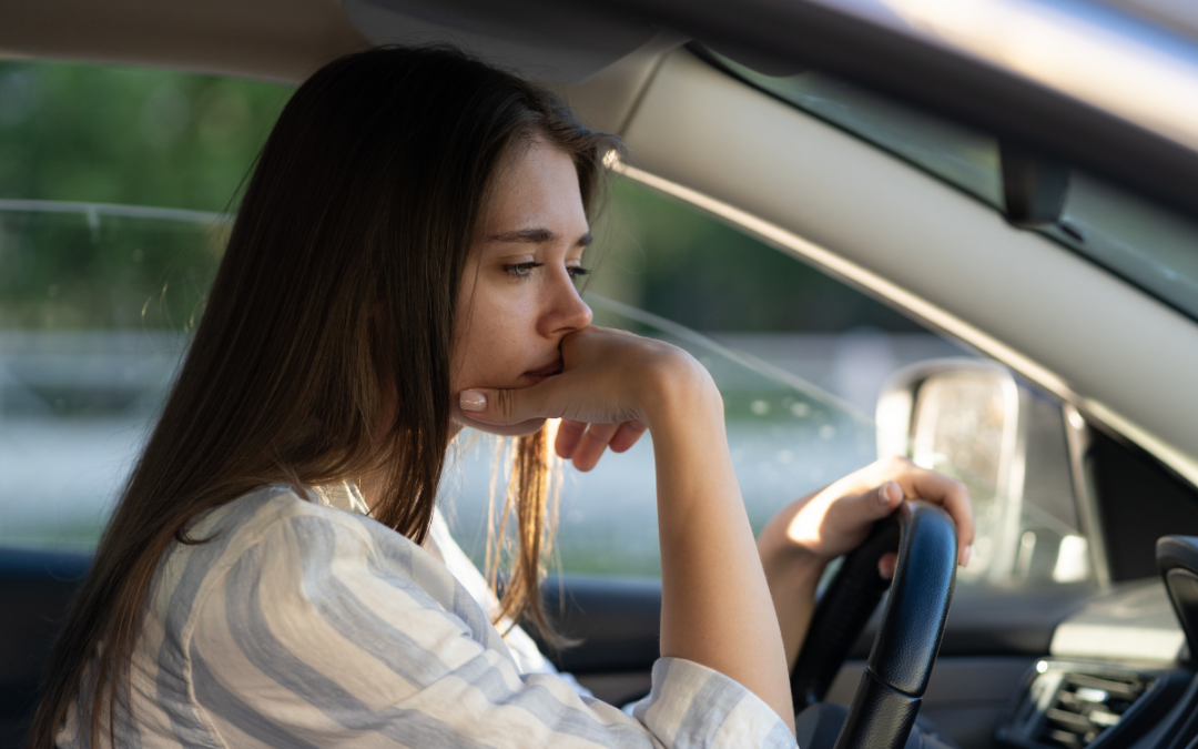 Woman sitting in car looking sad
