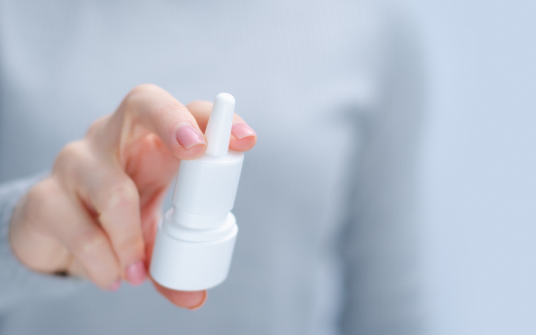 someone holding a nasal spray bottle